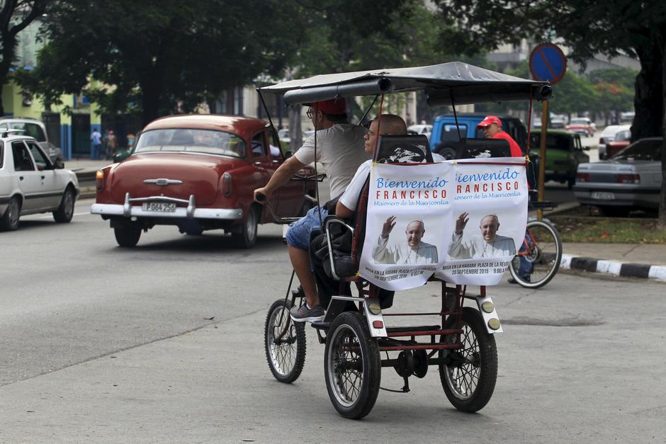 A man rides in a pedicab decorated with posters showing photographs of Pope Francis in downtown Havana, September 17, 2015. Pope Francis is due for a three-night visit to Cuba, starting on Saturday. Catholicism is flourishing again in the former Spanish c