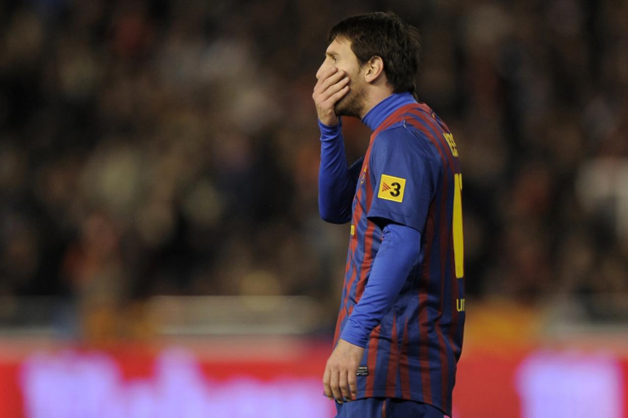 'Barcelona\'s Argentinian forward Lionel Messi reacts after missing a penalty during the Spanish Cup semi-final match Valencia CF vs Barcelona on February 01,2012 at the Mestalla stadium in Valencia.A