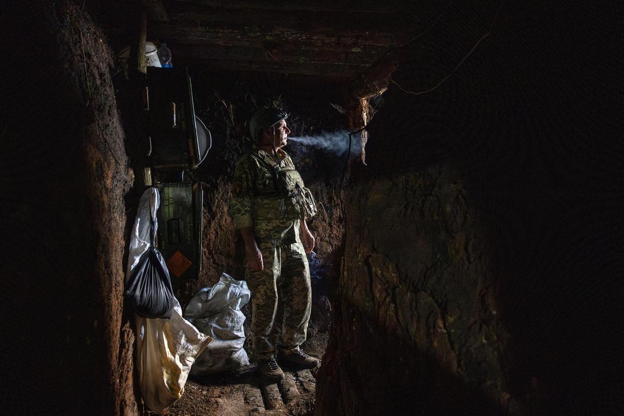 A soldier with the callsign Zubr of Ukraine’s 22nd Separate Mechanised Brigade stands in a dugout of an artillery position while waiting for a fire order at the outskirts of Chasiv Yar