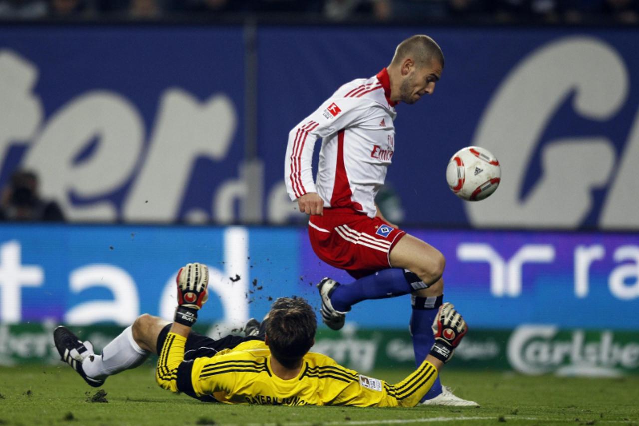 'Hamburg SV\'s Mladen Petric (R) fails to score past Bayern Munich\'s goalkeeper Joerg Butt during their German Bundesliga first division soccer match in Hamburg October 22, 2010. REUTERS/Christian Ch