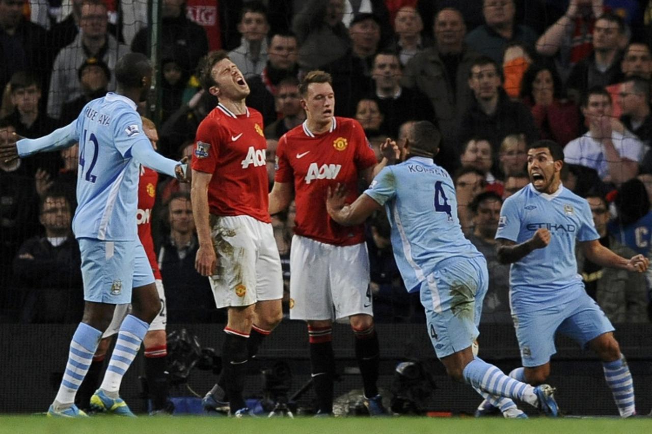 \'Manchester City\'s Vincent Kompany (2nd R) reacts with team mate Carlos Tevez (R) after scoring during their English Premier League soccer match against Manchester United at the Etihad stadium in Ma