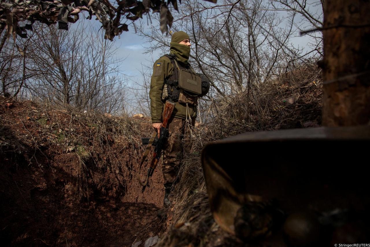 Ukrainian service member looks on from a trench at a position outside the frontline town of Horlivka