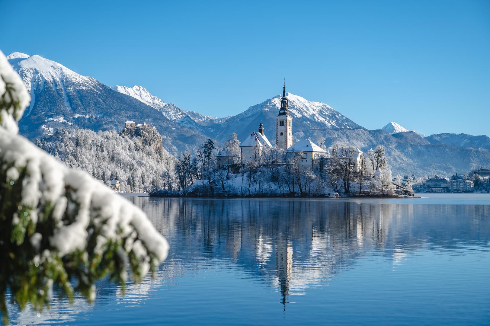 6. Bledsko jezero, Slovenija – Bajkoviti zimski raj: Zima na Bledu donosi mirnu i opuštajuću atmosferu, idealnu za šetnje uz zaleđeno jezero ili posjet Bledskom otoku. Posjetitelji mogu doživjeti čaroliju ovog mjesta posjetom impozantnom Bledskom dvorcu, koji pruža prekrasan pogled na okolicu, te se opustiti u lokalnim wellness centrima koji nude razne tretmane za obnovu tijela i duha. Ljubitelji slatkog ne smiju propustiti kušanje poznate Bledske kremšnite, kremaste poslastice s dugom tradicijom koja je postala simbol ovog mjesta. Za one koji žele doživjeti pravu zimsku idilu i uživati u miru i tišini, najbolje vrijeme za posjet je tijekom siječnja i veljače, kada snježni pokrivač dodatno naglašava ljepotu ovog bajkovitog krajolika.