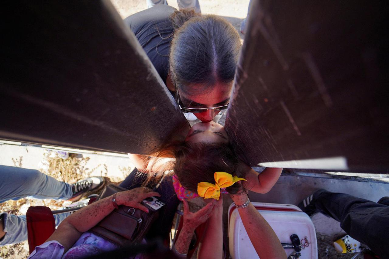 Family members meet at the border fence, in Mexicali