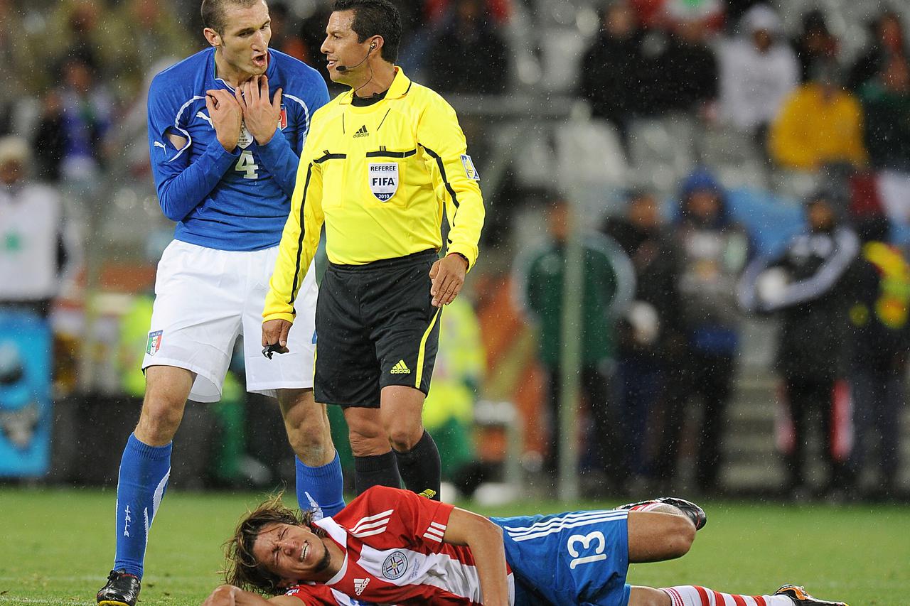 Referee Benito Archundia Tellez (centre) has words with Italy's Giorgio Chiellini (left) after a foul on Paraguay's Enrique Vera (right)  Photo: Press Association/PIXSELL