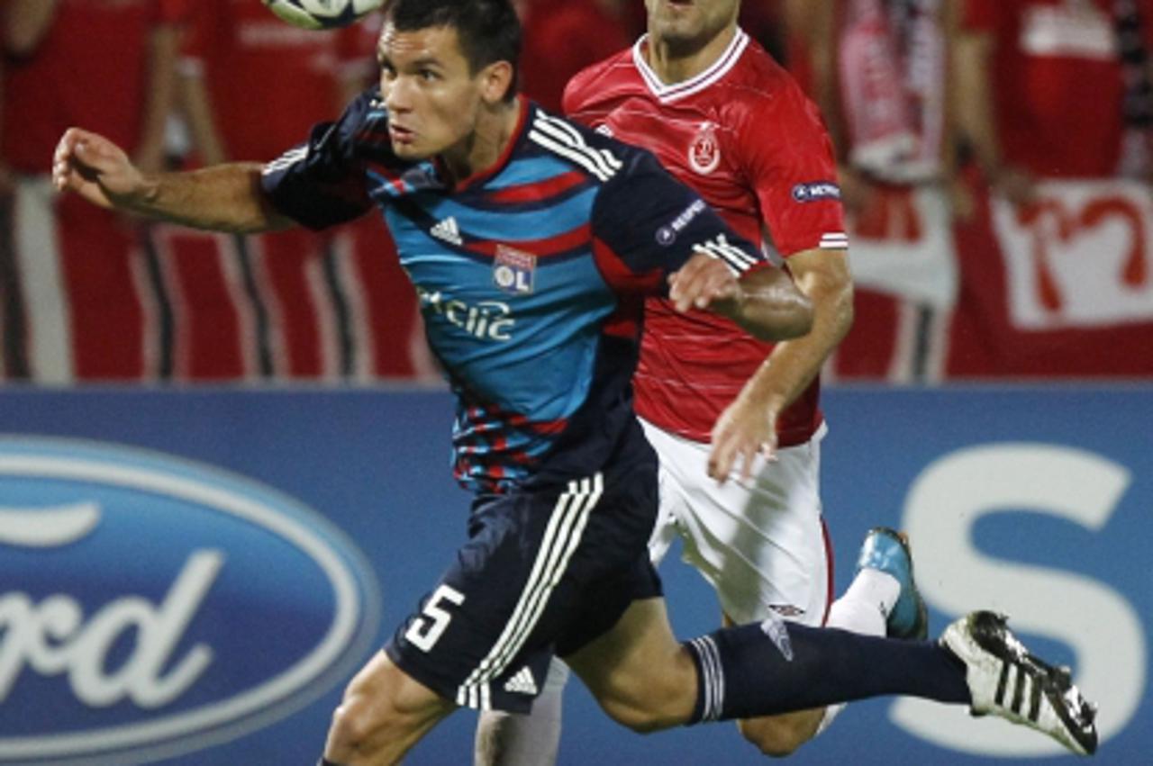 \'Olympique Lyon\'s Dejan Lovren (L) challenges Hapoel Tel Aviv\'s Etey Schechter during their Champions League Group B soccer match at Bloomfield stadium in Tel Aviv September 29, 2010. REUTERS/Ronen