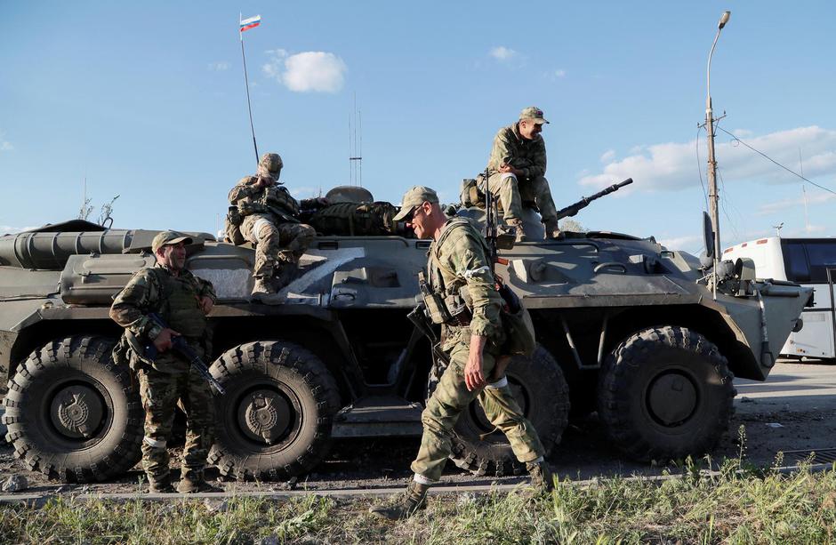 Service members of pro-Russian troops stand guard in Mariupol