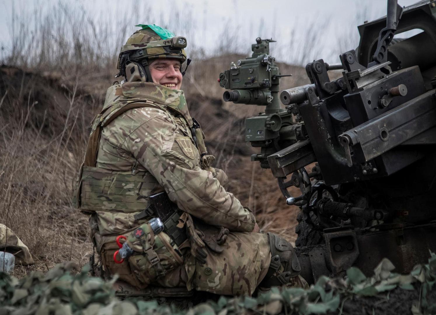 A Ukrainian service member from a battalion, named of nom-de-guerre of their commander 'Da Vinci', Hero of Ukraine, who was killed in a fight against Russian troops, smiles as he fires a howitzer M119 at a front line, amid Russia's attack on Ukraine, near the city of Bakhmut, Ukraine March 10, 2023. REUTERS/Oleksandr Ratushniak Photo: Stringer/REUTERS