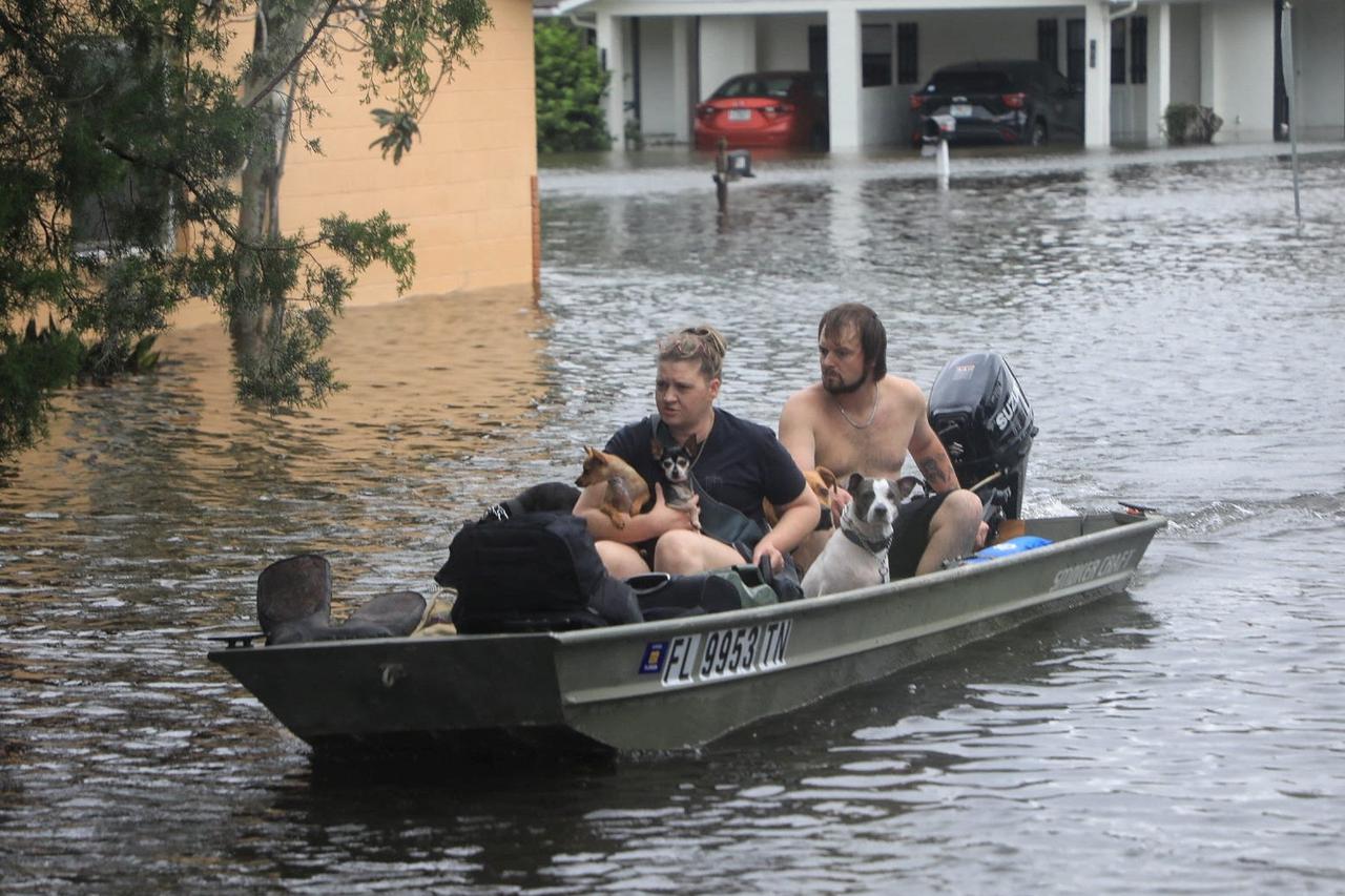 Residents and their pets evacuate Magnolia Avenue after Hurricane Milton flooded the neighbourhood in South Daytona