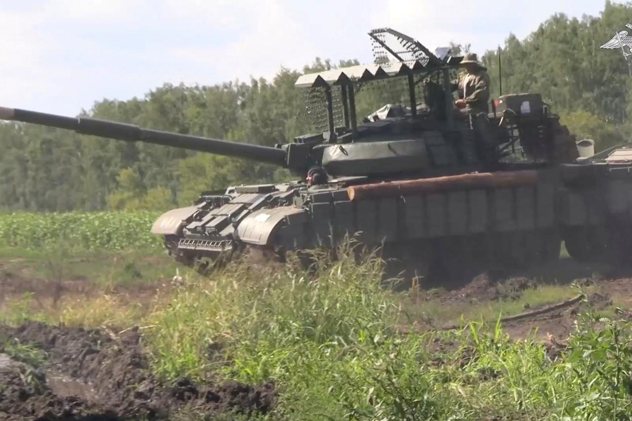 Russian service members drive a tank in the area bordering Ukraine in Kursk region