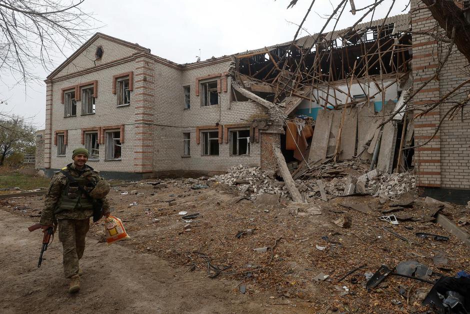 Ukrainian serviceman walks past a building of a kindergarten damaged during a Russian missile attack in the village of Novooleksandrivka, in Kherson region