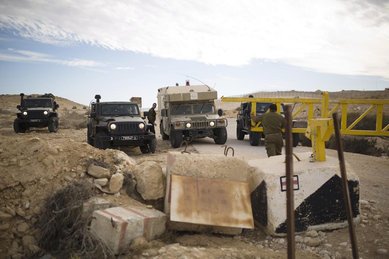 An Israeli soldier closes a gate that leads to the border fence between Israel and Egypt October 22, 2014. Attackers on Egypt's Sinai peninsula opened fire on Israeli soldiers across the border on Wednesday, wounding two, the Israeli military said. Islami