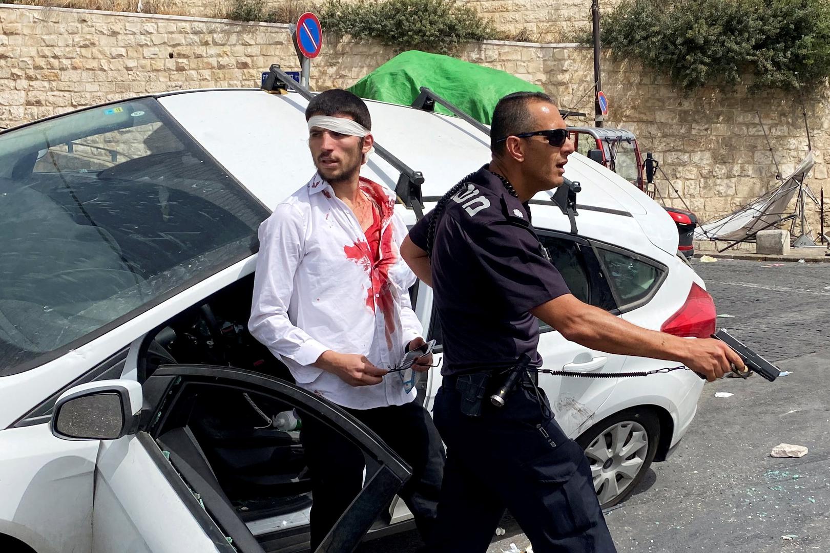 An Israeli police officer holds his weapon as he stands in front of an injured Israeli driver moments after witnesses said his car crashed into a Palestinian on a pavement during stone-throwing clashes near Lion's Gate just outside Jerusalem's Old City An Israeli police officer holds his weapon as he stands in front of an injured Israeli driver moments after witnesses said his car crashed into a Palestinian on a pavement during stone-throwing clashes near Lion's Gate just outside Jerusalem's Old City May 10, 2021. REUTERS/Ilan Rosenberg     TPX IMAGES OF THE DAY ILAN ROSENBERG