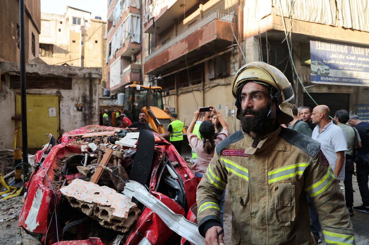 People gather at the site of an Israeli strike in Beirut's southern suburbs