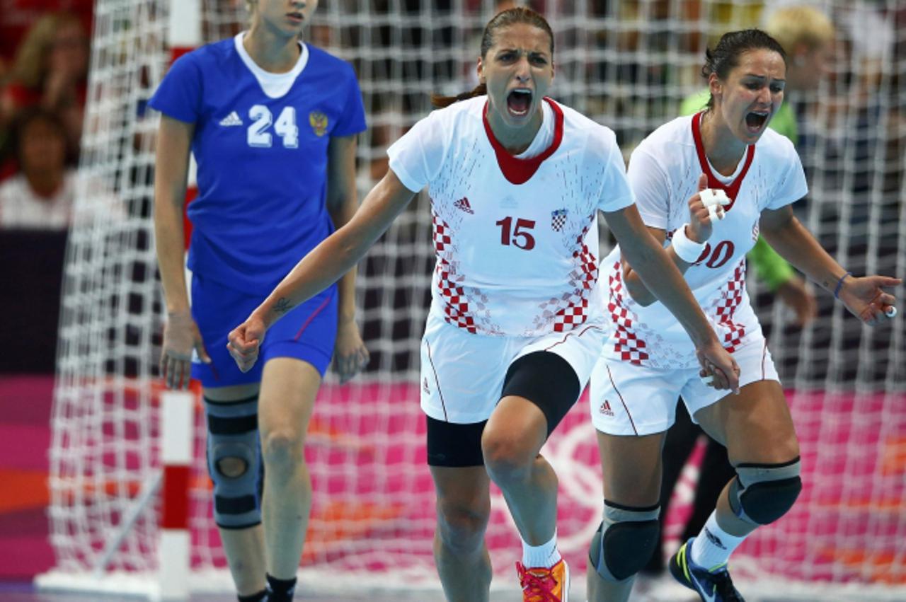 'Croatia\'s Andrea Penezic (C) and Nikica Pusic-Koroljevic celebrate a goal against Russia\'s in their women\'s handball Preliminaries Group A match at the Copper Box venue during the London 2012 Olym