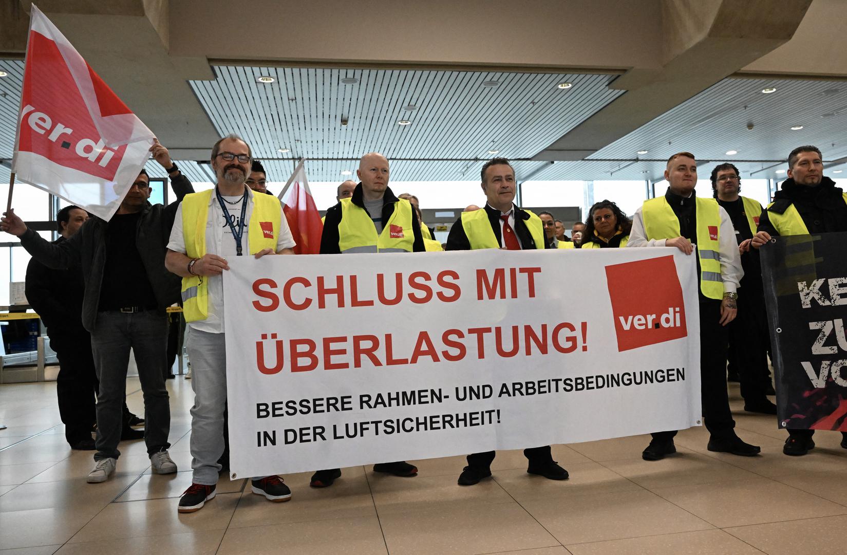 Aviation security workers of Germany's Verdi union gather at Cologne-Bonn airport during a strike in Cologne, Germany, April 20, 2023. The placard reads "end pressure of work". REUTERS/Jana Rodenbusch Photo: JANA RODENBUSCH/REUTERS