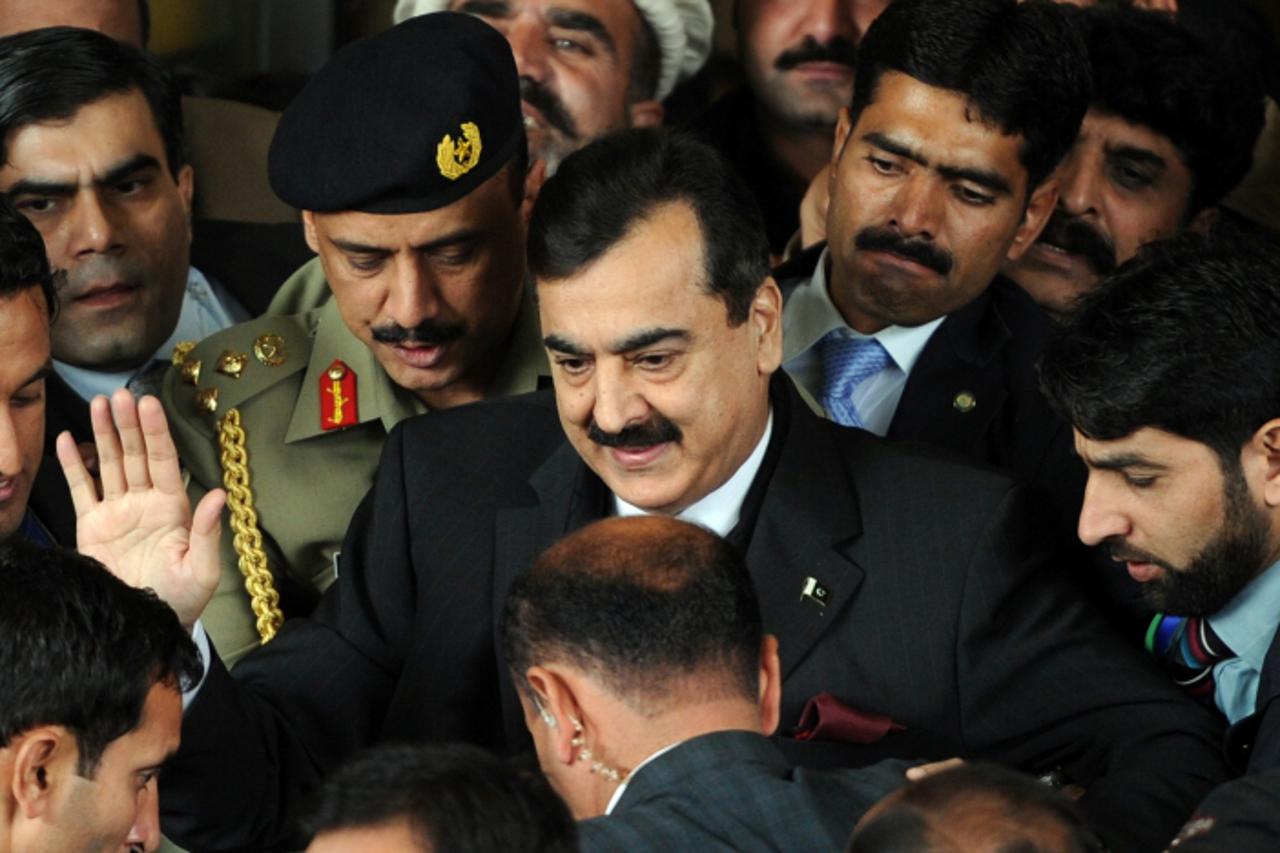 'Pakistani Prime Minister Yousuf Raza Gilani (C) surrounded by security personnel and lawyers leaves the Supreme Court after adjourning the contempt hearing in Islamabad on January 19, 2012. Pakistan\