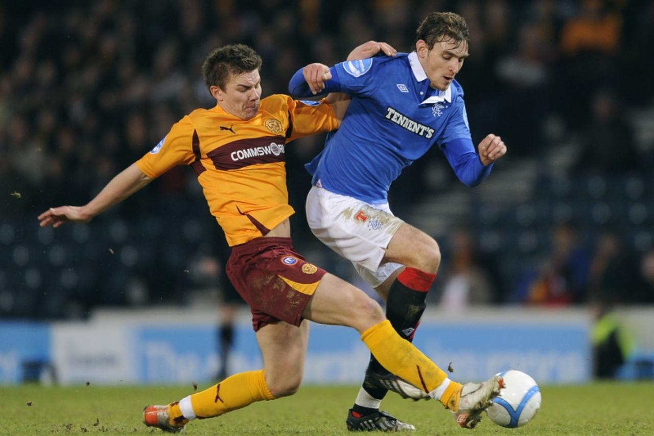 'Motherwell\'s Shaun Hutchinson challenges Rangers\' Nikica Jelavic (R) during their Scottish League Cup semi final soccer match at Hampden Park ,Glasgow, Scotland, January 30, 2011. REUTERS/Russell C