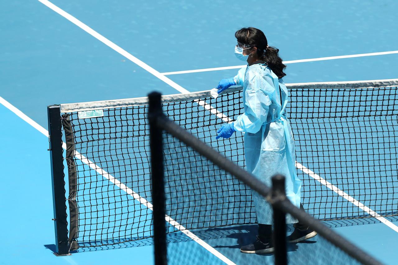 FILE PHOTO: A staff member wearing PPE works to clean surfaces at Melbourne Park in Melbourne