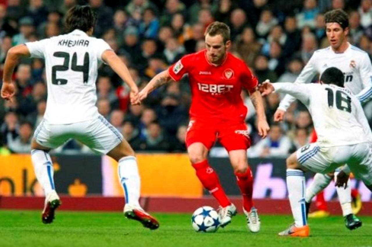 'MD150. MADRID, 02/02/2011.- El centrocampista croata del Sevilla CF, Ivan Rakitic (c), controla el balَn entre los jugadores del Real Madrid, el alemلn Sami Khedira (i) y Raْl Albiol, durante el part