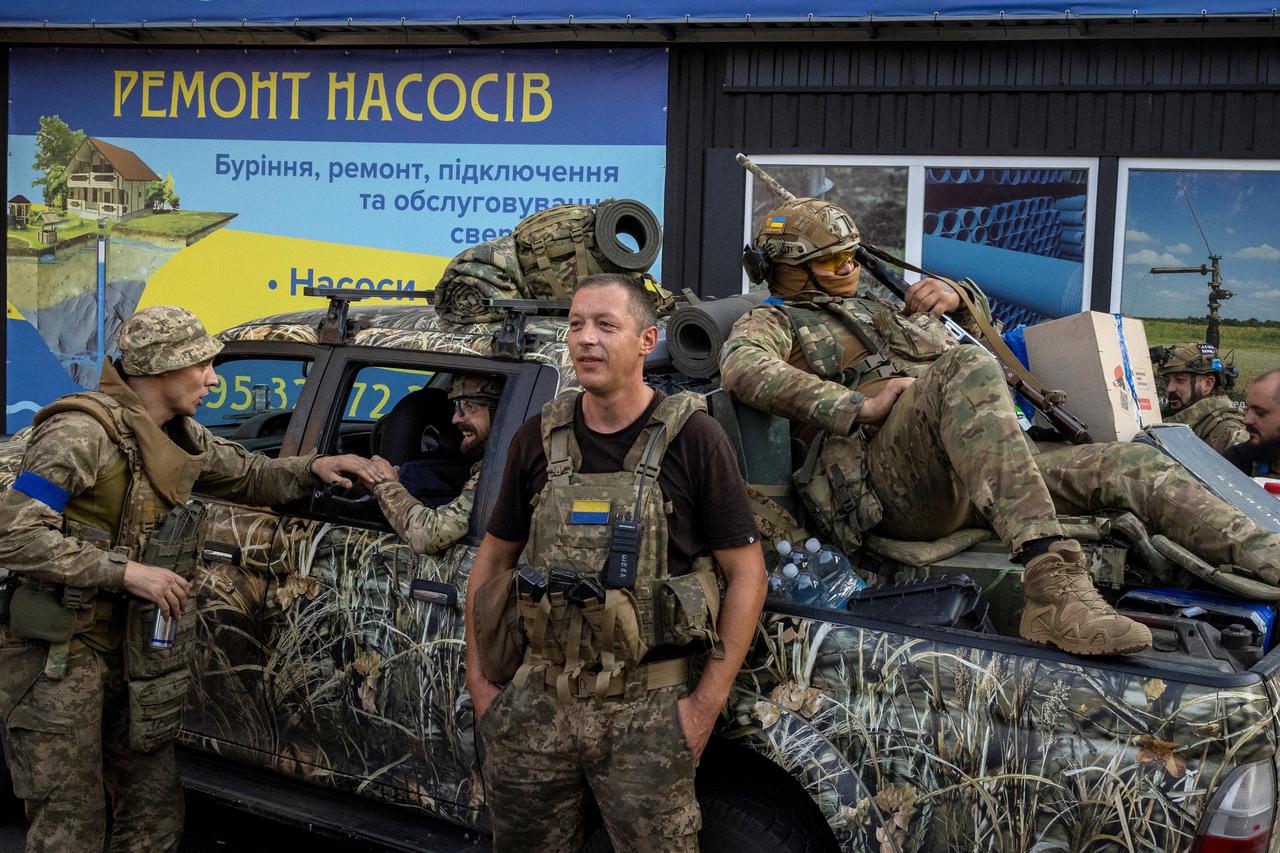 Ukrainian servicemen gather around a pickup truck in Pokrovsk, Ukraine, as they prepare to move into battle