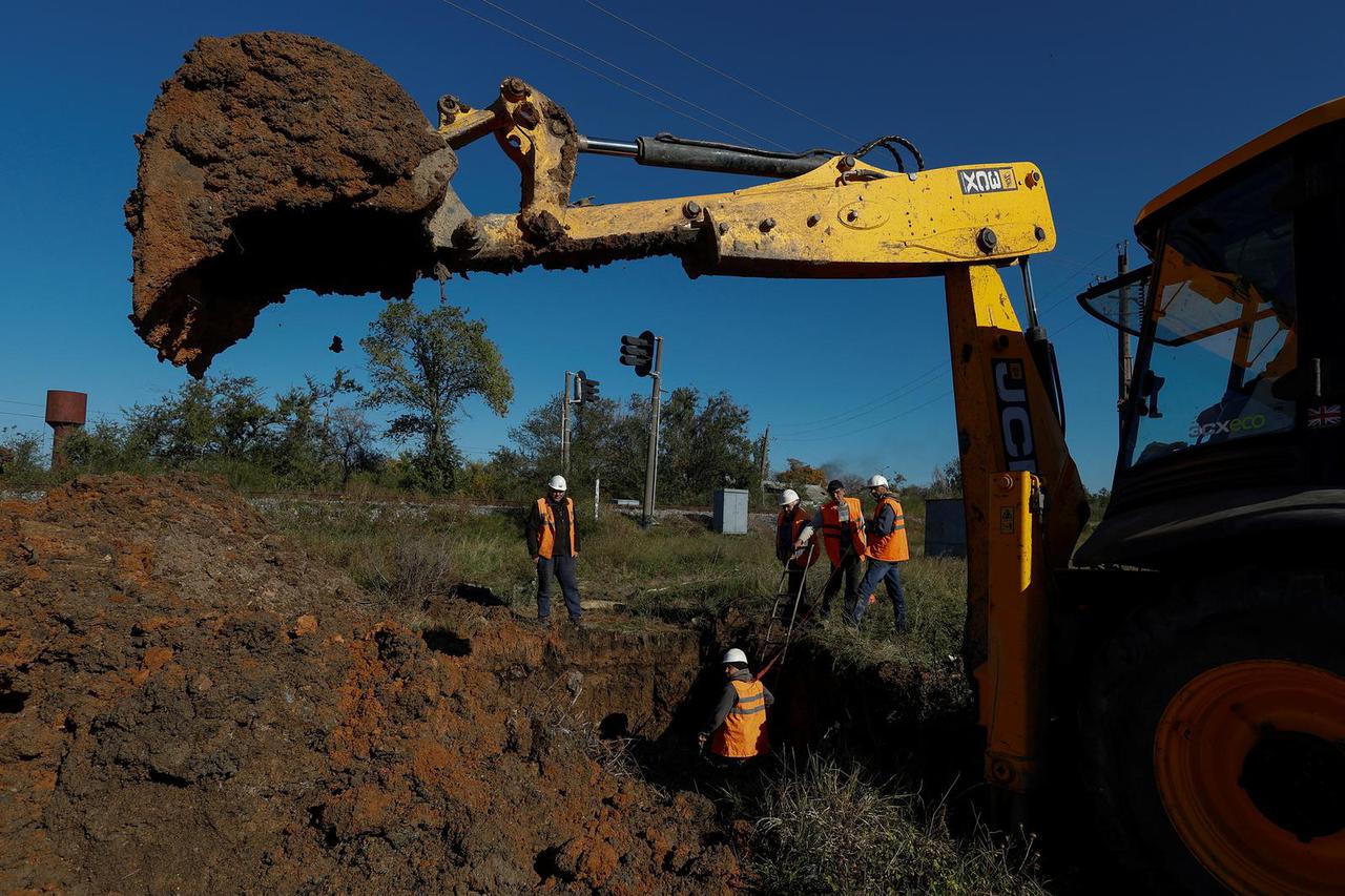 Employees of a municipal water supply company repair damaged water pipes in Mykolaiv