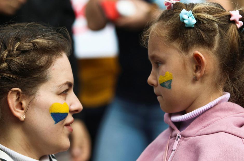 A mother talks to her child during a protest against Russia's military operation in Ukraine, outside the Presidential Palace in Nicosia