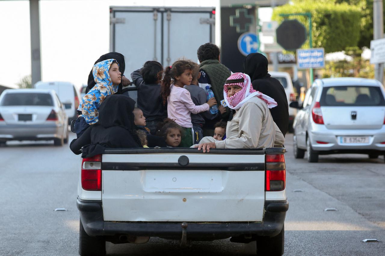 People gather at the site of an Israeli strike in Beirut's southern suburbs