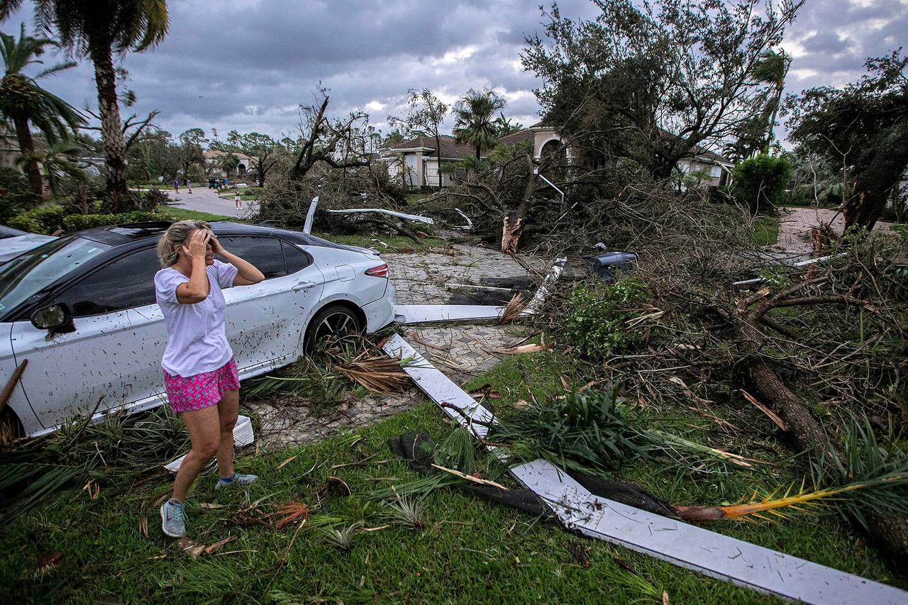 Marie Cook reacts to the damage to her home in the Binks Estates community after a tornado formed by Hurricane Milton touched down