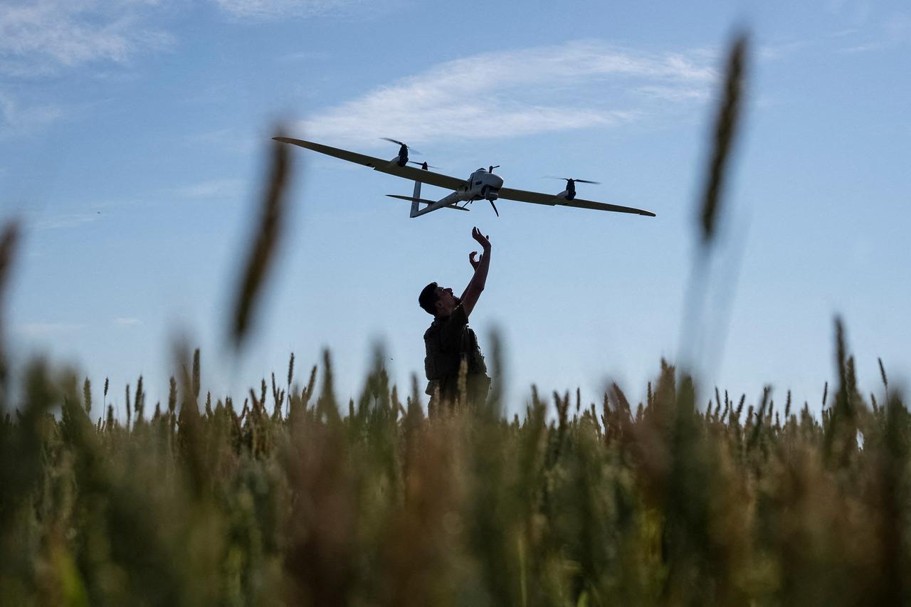 A Ukrainian serviceman launches a mid-range reconnaissance type drone, Vector, for flying over positions of Russian troops in a Kharkiv region