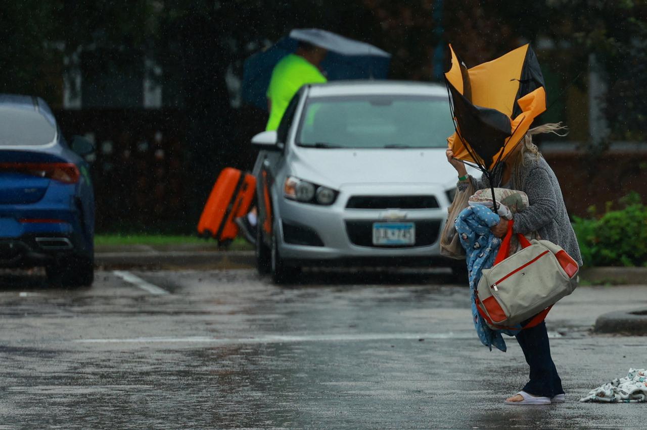 Residents and their pets evacuate Magnolia Avenue after Hurricane Milton flooded the neighbourhood in South Daytona