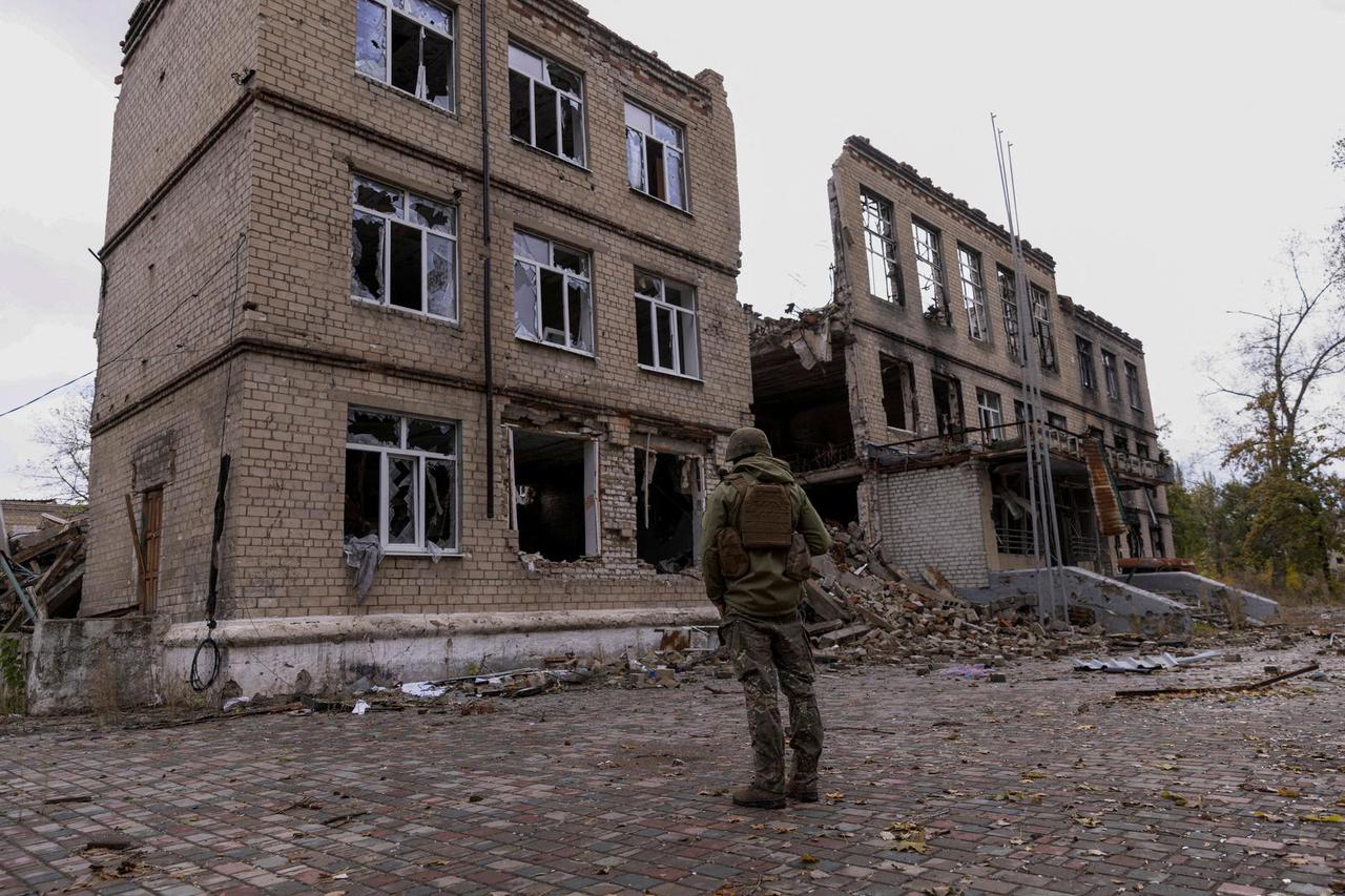 FILE PHOTO: Police officer walks near a damaged residential building in Avdiivka