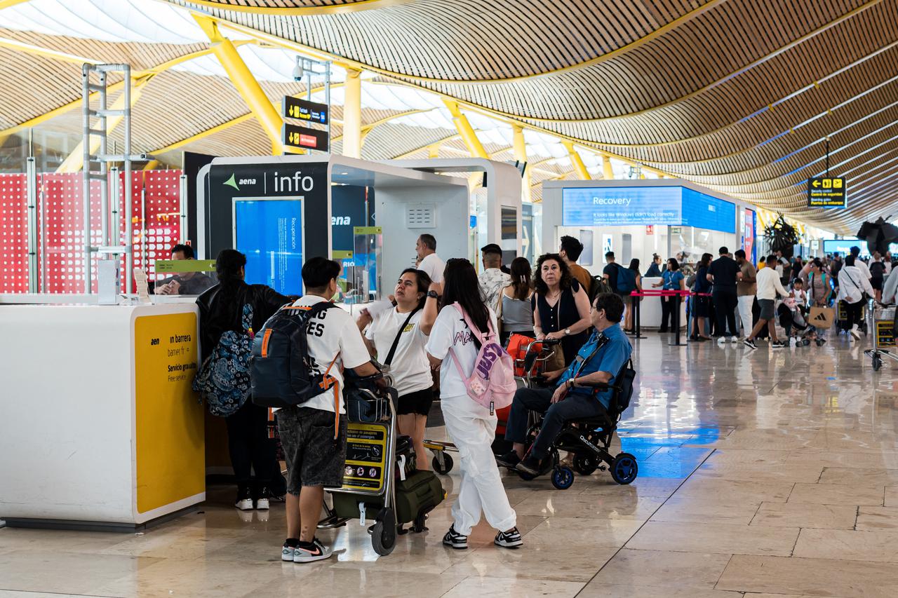 Passengers at Madrid-Barajas airport during the crash of Microsoft's security system that has caused failures at major companies around the world,