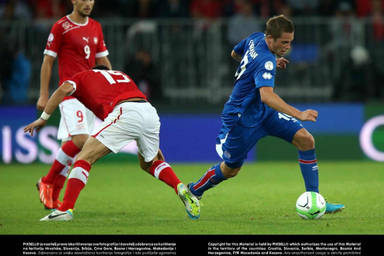 'Iceland\'s Gylfi Sigurdsson evades the challenge of Switzerland\'s Blerim Dzemaili (left).Photo: Press Association/PIXSELL'