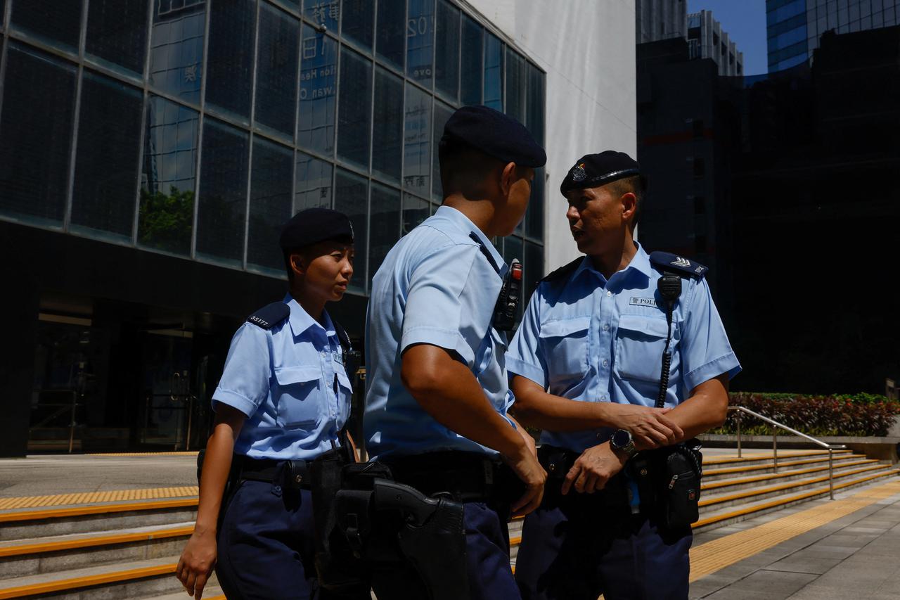 Police stand guard outside the District Court during a landmark sedition trial against two former editors of now-shuttered online media Stand News, in Hong Kong