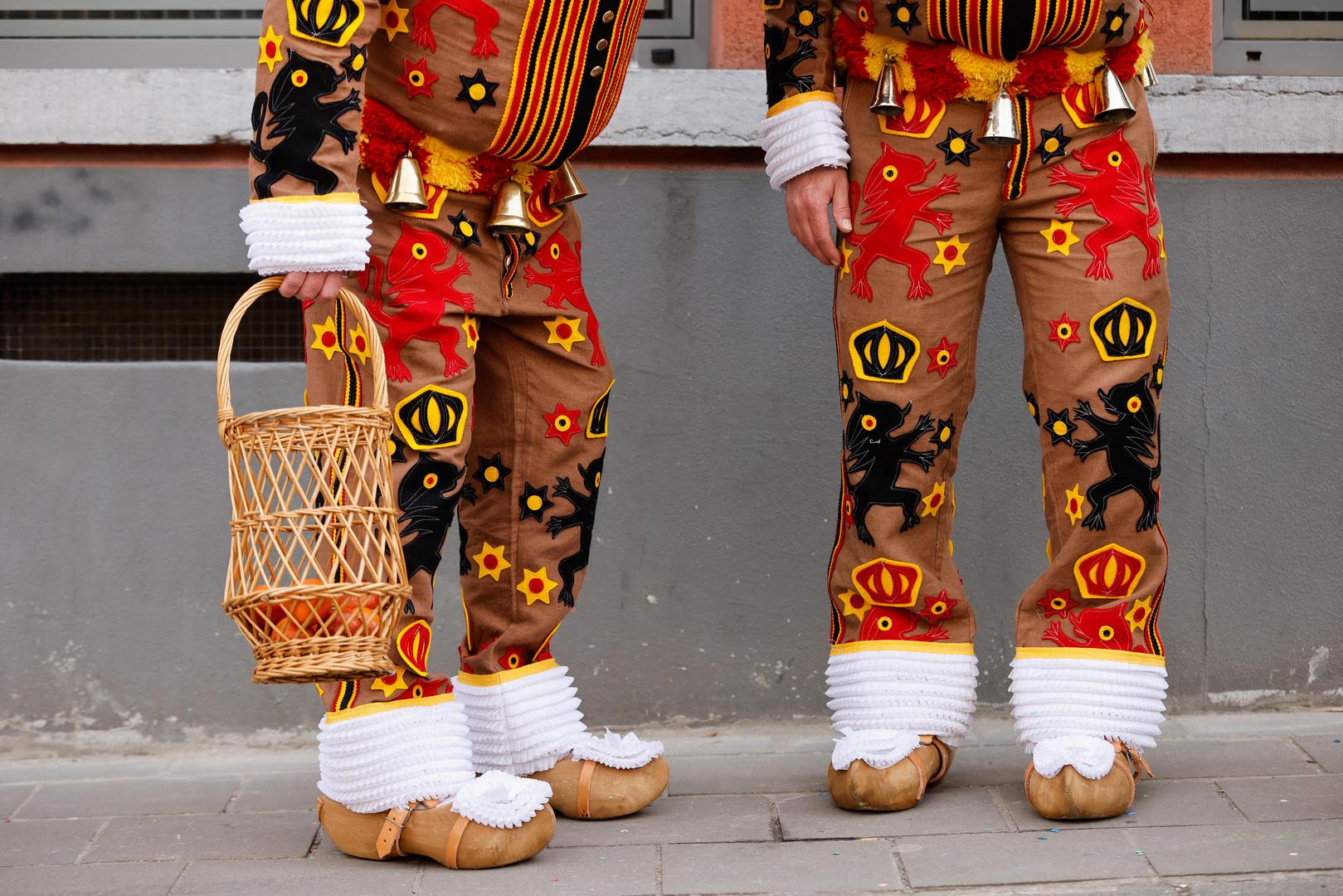 People wearing costumes stand near the site where a vehicle drove into a group of Belgian carnival performers who were preparing for a parade in the village of Strepy-Bracquegnies, Belgium March 20, 2022. REUTERS/Johanna Geron Photo: JOHANNA GERON/REUTERS