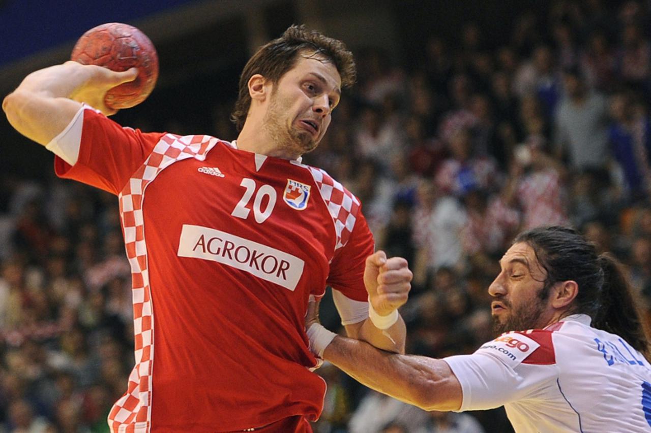 'Croatian Damir Bicanic (L) throws and scores past French Bertrand Gille during the men\'s EHF Euro 2012 Handball Championship match between France and Croatia at the sports hall in Novi Sad on Januar