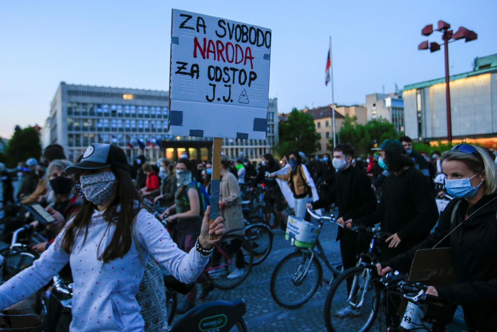 Protesters ride bicycles during an anti-government protest in Ljubljana A protester wearing a protective mask holds a placard that reads: "For freedom of people for resignation of J.J." during an anti-government demonstration, as the spread of the coronavirus disease (COVID-19) continues, in Ljubljana, Slovenia May 8, 2020. REUTERS/Borut Zivulovic BORUT ZIVULOVIC