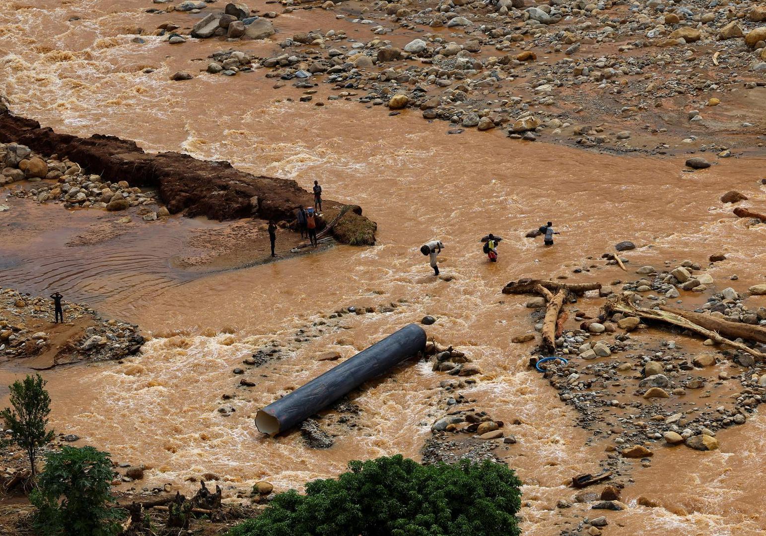 FILE PHOTO: People cross a flooded area in Muloza on the border with Mozambique after the aftermath of Tropical Cyclone Freddy, around 100 km outside Blantyre, Malawi, March 18, 2023. REUTERS/Esa Alexander/File Photo Photo: ESA ALEXANDER/REUTERS