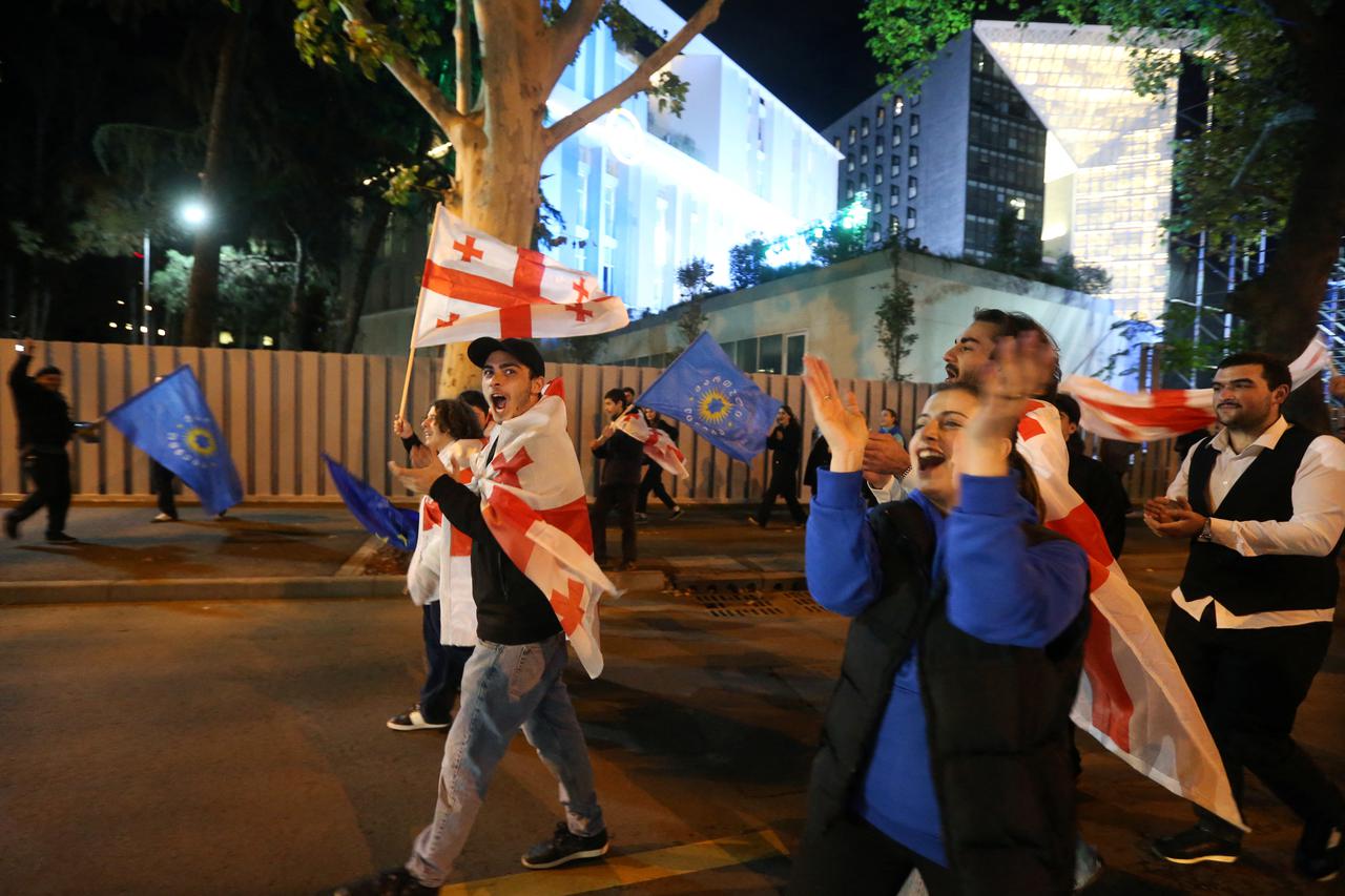 Supporters of the Georgian Dream party celebrate after the announcement of exit poll results in Tbilisi