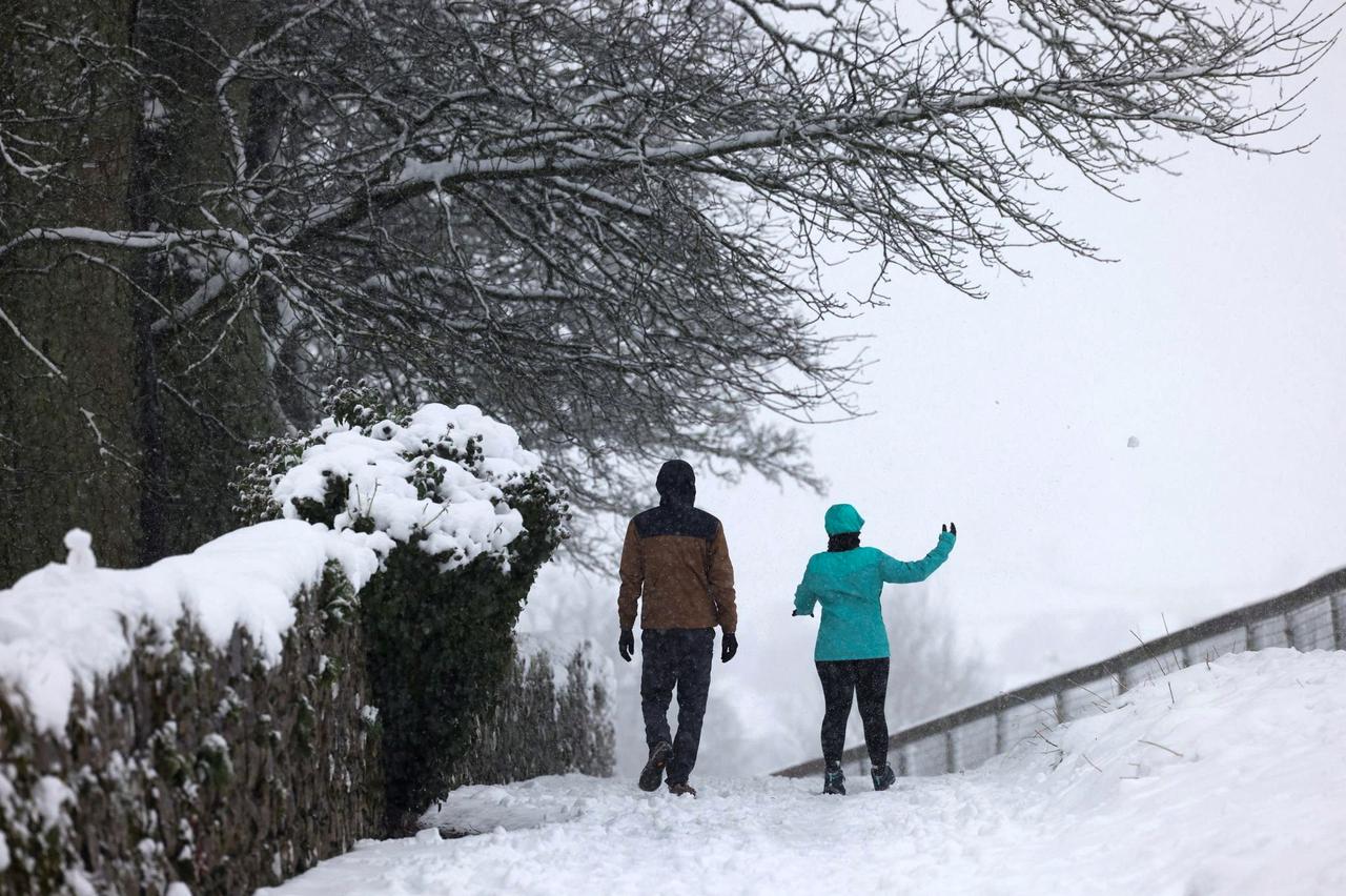 A couple walks in the snow in Cashel