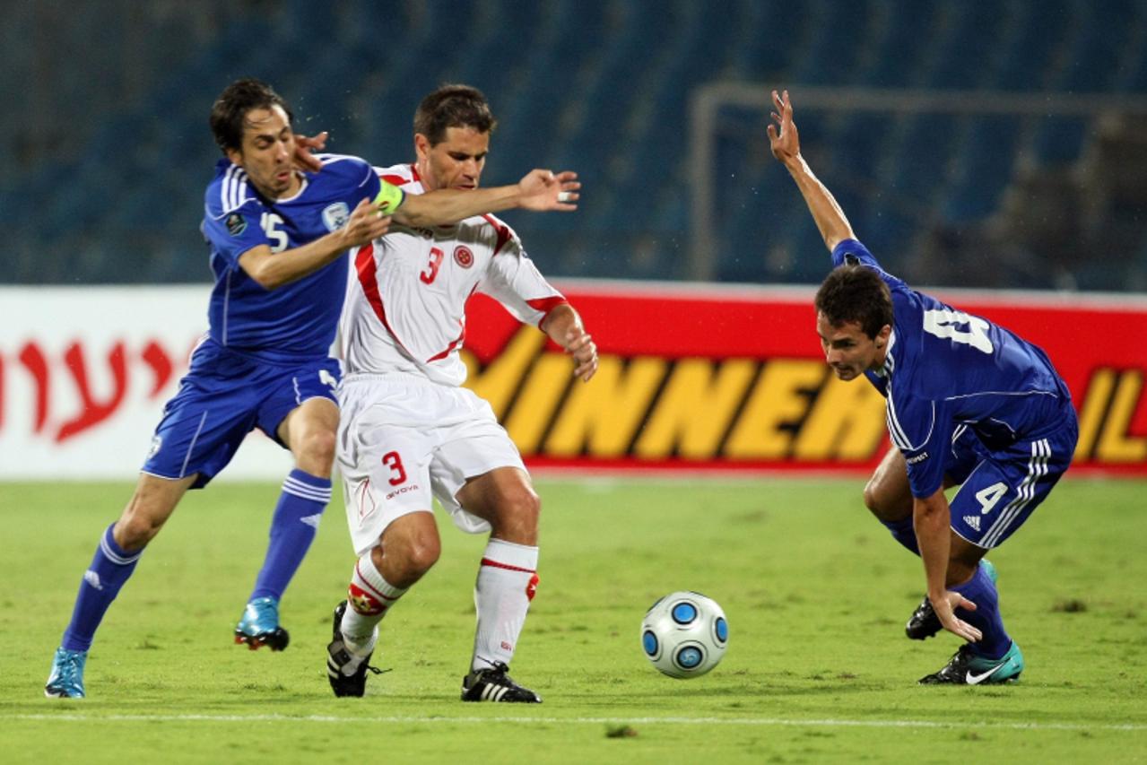 'Malta\'s Carlo Mamo (C) fights for the ball with Dani Bonder (R) and Yossi Benayoun (L) of Israel during their Euro 2012 qualifying group F football match at Ramat Gan stadium near Tel Aviv on Septem