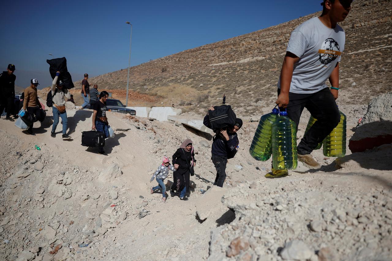 People cross from Lebanon into Syria on foot at the Masnaa border crossing