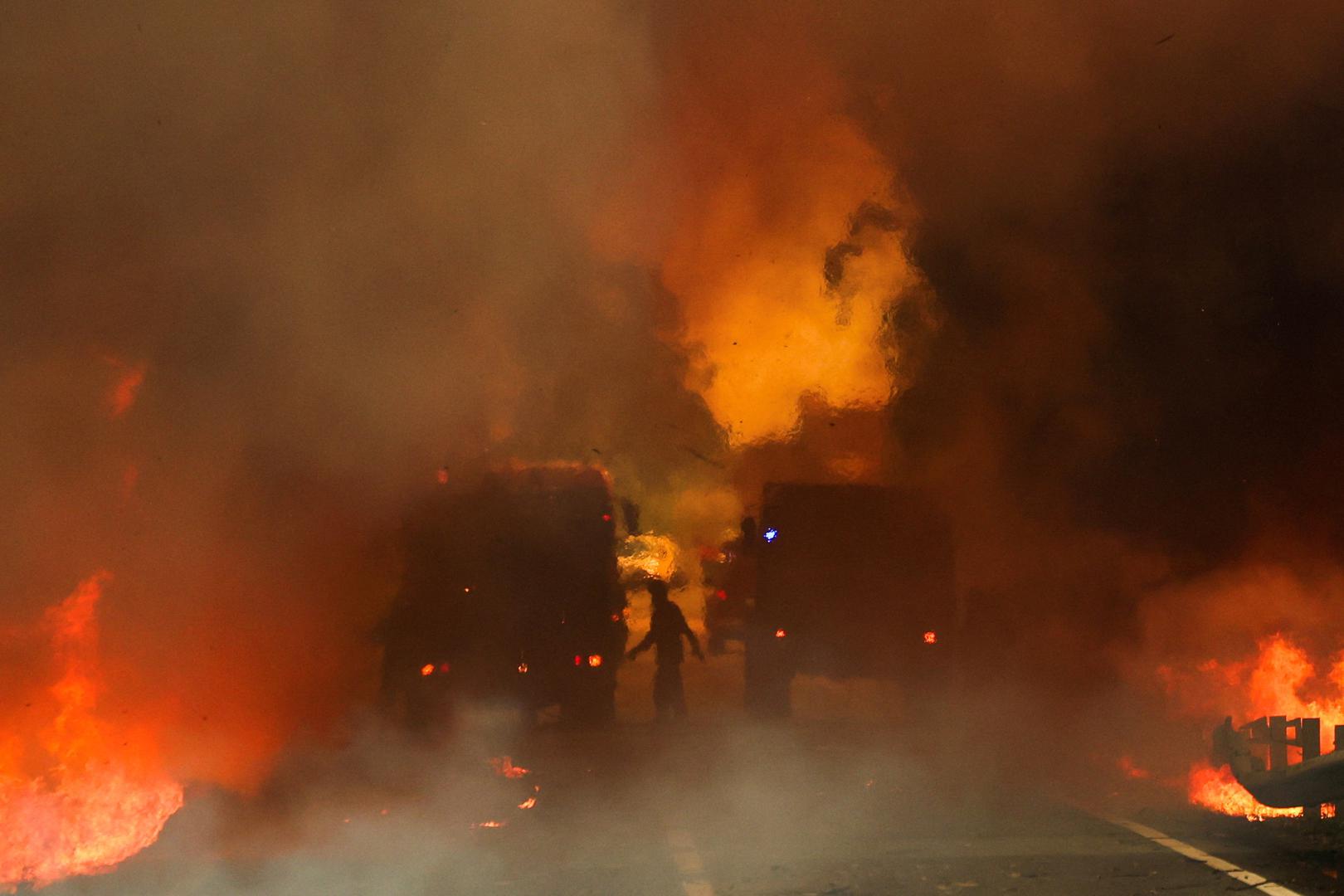 Firefighters try to extinguish a wildfire on a road in Junqueiro, Agueda, Portugal, September 17, 2024. REUTERS/Pedro Nunes     TPX IMAGES OF THE DAY Photo: PEDRO NUNES/REUTERS