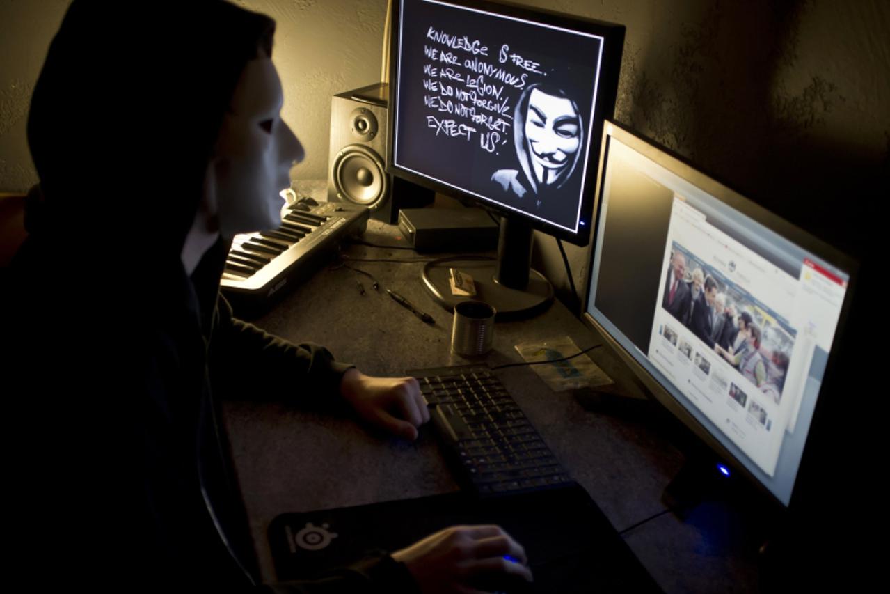 'A masked hacker, part of the Anonymous group, hacks the French presidential Elysee Palace website on January 20, 2012 near the eastern city of Lyon. Anonymous, which briefly knocked the FBI and Justi