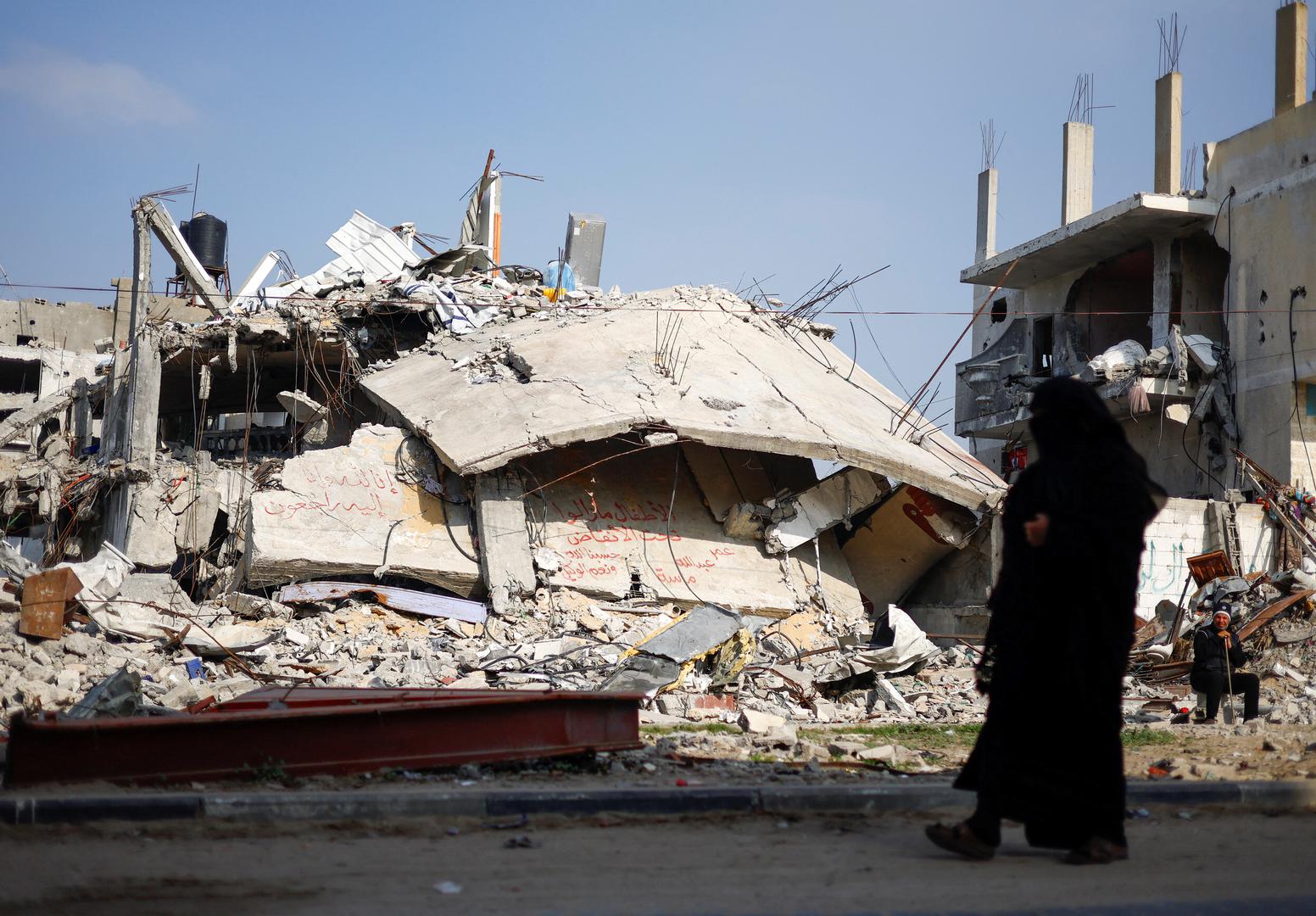 Ziad Mansour, a neighbour of the Abu Aweidah family, sits next to writing painted on a wall amid the rubble of the family's house, which was destroyed in a deadly Israeli strike amid the ongoing conflict between Israel and the Palestinian Islamist group Hamas, in Rafah, Gaza Strip, January 9, 2024. The writing reads: "Children remaining under the rubble, Oman, Abdullah and Massa". REUTERS/Mohammed Salem Photo: MOHAMMED SALEM/REUTERS