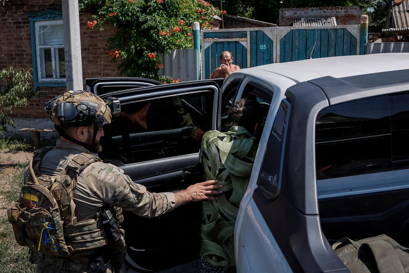 Levon, 30, Ukrainian police officer, helps Olha, 52, local resident who is being evacuated, to sit in a police evacuation vehicle, amid Russia's attack on Ukraine, in the town of Toretsk, near a front line in Donetsk region, Ukraine July 3, 2024. REUTERS/Alina Smutko Photo: ALINA SMUTKO/REUTERS