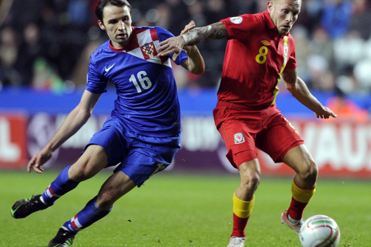 'Wales\' Craig Bellamy (R) challenges Croatia\'s Milan Badelj during the FIFA 2014 World Cup qualifying soccer match at the Liberty Stadium in Swansea, Wales, March 26, 2013.  REUTERS/Rebecca Naden (B