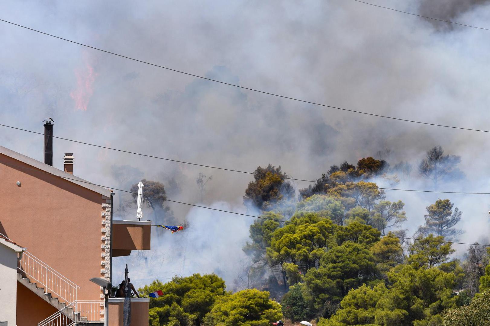 06.08.2024., Sibenik - Nesto prije 13 sati izbio je pozar u borovoj sumi u sibenskom naselju Rokici, odmah pokraj bolnice i stambenih kuca. Na terenu su vatrogasci i policija, a pozvana je i pomoc iz zraka. Suma se nalazi iznad Jadranske magistrale koja je zbog pozara zatvorena za sav promet. Photo: Hrvoje Jelavic/PIXSELL