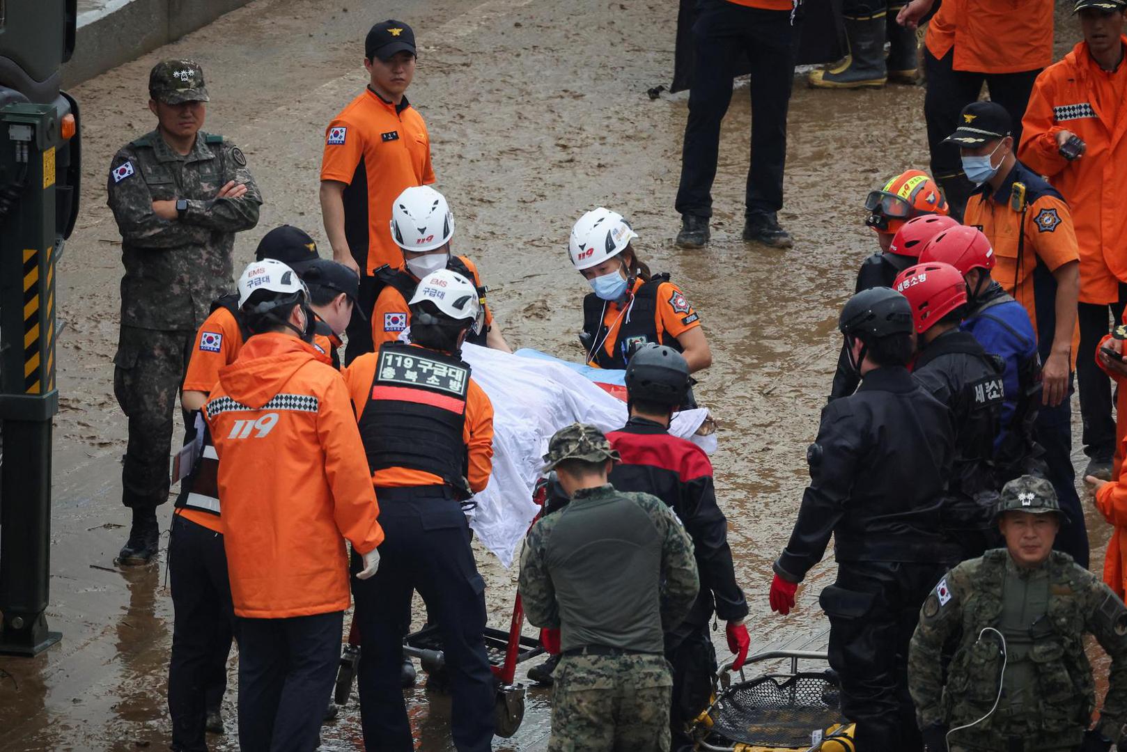 SENSITIVE MATERIAL. THIS IMAGE MAY OFFEND OR DISTURB Rescue workers move the body of a victim recovered during a search and rescue operation near an underpass that has been submerged by a flooded river caused by torrential rain in Cheongju, South Korea, July 16, 2023.   REUTERS/Kim Hong-ji Photo: KIM HONG-JI/REUTERS